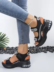 Close-up of black platform sandals with rhinestones and Sport lettering details