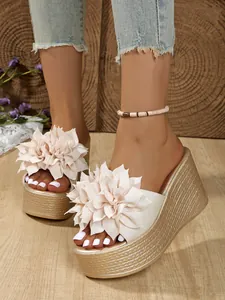 Vue détaillée d'élégantes sandales compensées à fleurs crème avec texture de plateforme.