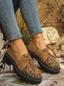 Close-up of leopard print platform loafers with chunky soles and tan suede finish
