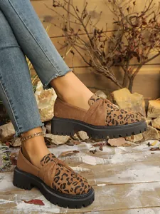 Detail of leopard print platform loafers on model with gold chain anklet