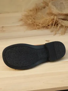 Close-up macro view of the textured non-slip black sole on women's platform loafers