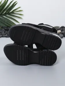 Detailed bottom view of black platform sandals with non-slip sole and air cushion