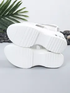 Close-up of white platform sandal soles featuring detailed anti-slip tread patterns
