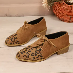 Close-up of elegant leopard print suede shoes with lace-up side details and pointed toe design