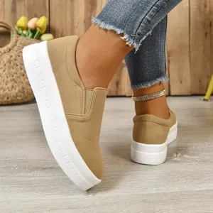 Close-up side view of khaki suede slip-on sneakers with a thick white platform sole