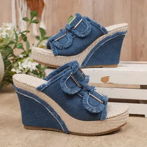 Close-up view of stylish blue denim wedge sandals with fringe accents and platform soles