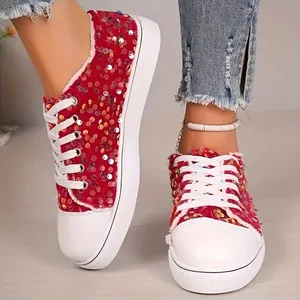 Gros plan sur des baskets en toile à paillettes rouges avec lacets et semelle blancs