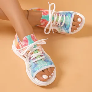 Vue détaillée de sandales en tricot tie-dye colorées avec lacets blancs et bout ouvert.