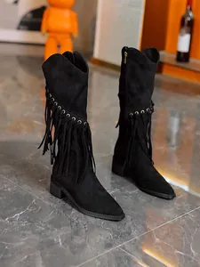Detail view of black suede knight boots featuring elegant fringe and side zipper closure.