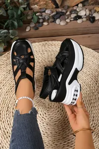 Close-up detail of stylish black women's platform sandals featuring closed-toe woven straps
