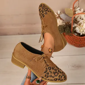 Detailed view of women's leopard print suede pointed toe shoes with unique side lace-up design