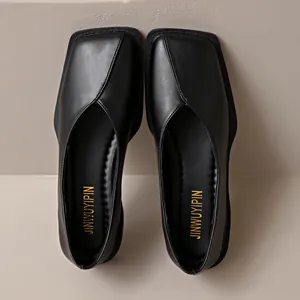 Primer plano de zapatos planos negros de punta cuadrada con elegante diseño en V