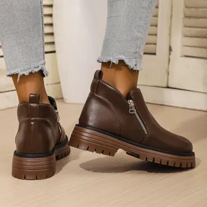 Close-up of stylish dark brown platform Martin boots with zipper and thick rubber sole