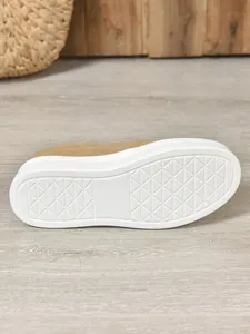 Detailed close-up of the non-slip thick white sole on khaki suede slip-on sneakers