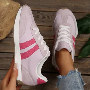 Close-up detail of pink retro sneakers with stripe accents and platform sole