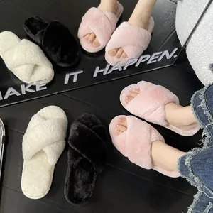 Primo piano di pantofole di peluche con fasce incrociate in rosa, bianco e nero