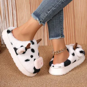 Close-up of cute cow plush slippers with thick non-slip soles for winter warmth.