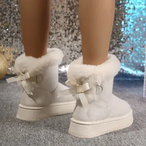 Detail of white snow boots featuring plush faux fur trim and elegant ribbon bow.