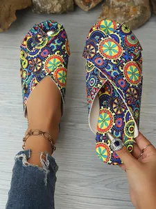 Vibrant ethnic mandala print flat sandals with criss-cross straps and toe-wrap design.