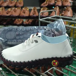 Close-up side view of white soft leather casual flat shoe with contrast stitching detail