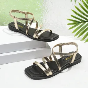 Vue détaillée des sandales romaines dorées à brides croisées et avec talon élastique