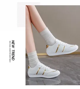 Vista dettagliata di sneakers bianche con strisce dorate e design laterale traforato