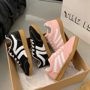 Baskets rétro roses et noires pour femmes dans une boîte, vue détaillée de chaussures plates