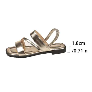 Detailansicht einer goldenen flachen Sandale mit einer Absatzhöhe von 1,8 cm oder 0,71 Zoll