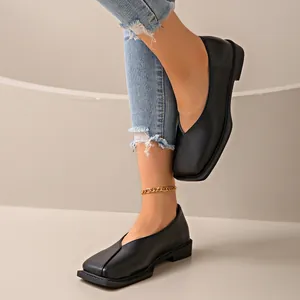 Vista detallada de zapatos planos negros de punta cuadrada con diseño retro en V