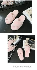 Pantofole in peluche rosa con cinturini incrociati in un ambiente di classe
