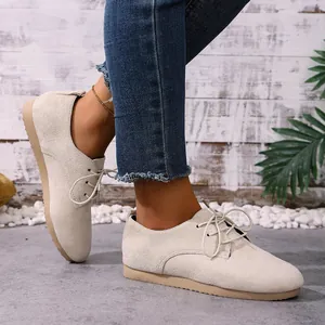 Close-up of stylish beige suede lace-up flats with a durable and comfortable gum sole