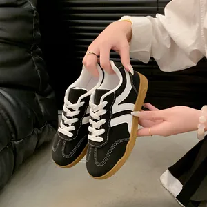 Détail de baskets rétro bicolores noir et blanc pour femmes, style entraîneur allemand