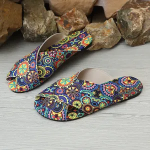 Detail of women's flat sandals with vibrant ethnic bohemian print and criss-cross straps