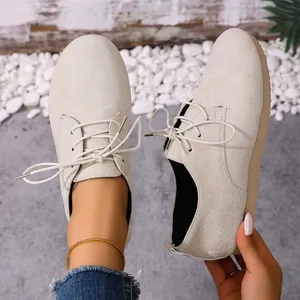 Macro view of women's beige suede lace-up shoes with thick anti-slip comfort sole.