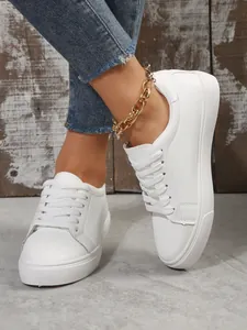 Close-up of women's white platform sneakers with lace-up casual style