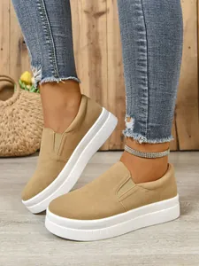 Close-up of khaki suede slip-on shoes with thick white platform soles