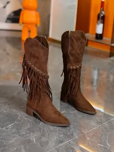 Detail of brown suede western boots with side fringe and metal grommets