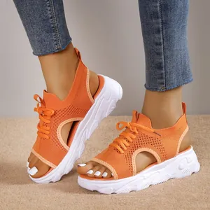 Detailansicht der orangefarbenen Fly-Knit Sport-Sandalen mit dicker weißer Sohle