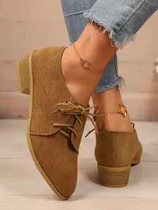 Detailed view of brown suede pointed toe lace-up shoes with stylish block heel