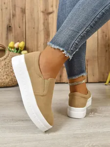 Detailed side view of women's khaki suede slip-on sneakers with a thick platform sole