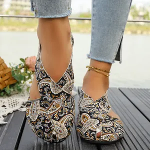 Close-up view of ethnic paisley printed closed-toe flat sandals for women in an outdoor setting