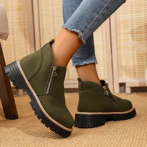 Detail view of olive green suede ankle boots with chunky lug sole and side zipper