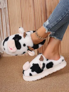 Plush cow-patterned slippers with thick anti-slip soles for cozy indoor winter warmth.