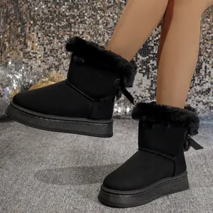 Stylish black snow boots with plush fur trim and back bow detail for winter warmth.