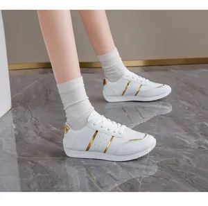 Eleganti sneaker bianche con accenti dorati indossate per un look casual versatile.