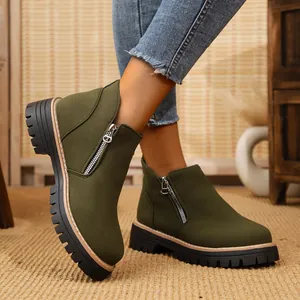 Detailed close-up of dark green suede ankle boots with side zipper and thick lug sole