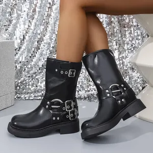 Macro view of black block heel Martin boots featuring silver buckle and stud details