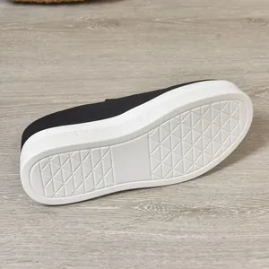 Close-up detail view showing the white anti-slip platform sole of black suede slip-on shoes