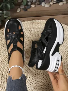 Detailed view of women's black and white platform sandals with woven leather straps