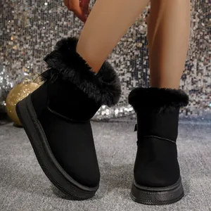 Close-up of black faux fur lined snow boots on model against festive glitter backdrop